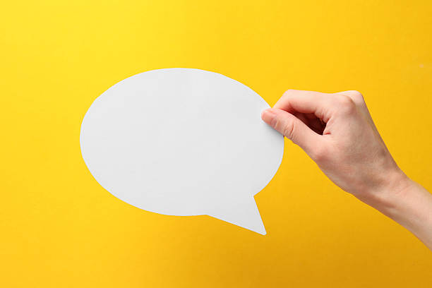 istock Woman holding blank speech bubble on yellow background, closeup. Space for text 2217198749
