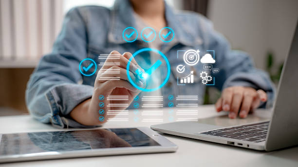 istock Person interacting with virtual digital checklist interface and quality verification icons, including task completion, cloud data, performance metrics, and workflow analytics in a tech workspace. 2217203187