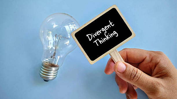 istock a hand holding notification board written with 'Divergent thinking' with light bulb beside it. 2217208688