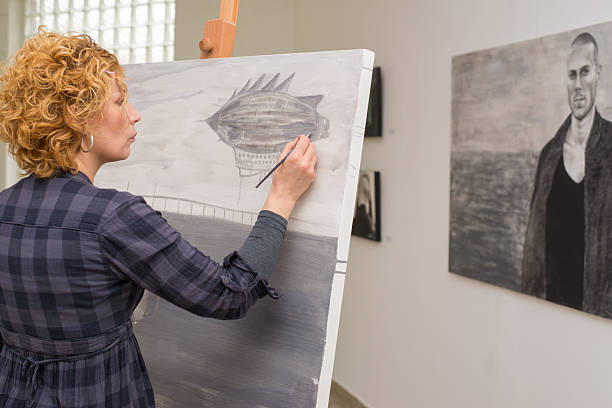 Young female painter painting in her studio