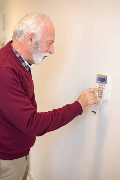 istock Senior man setting up home alarm 2217211584