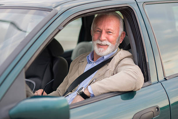 istock Smiling senior man driving car 2217211618