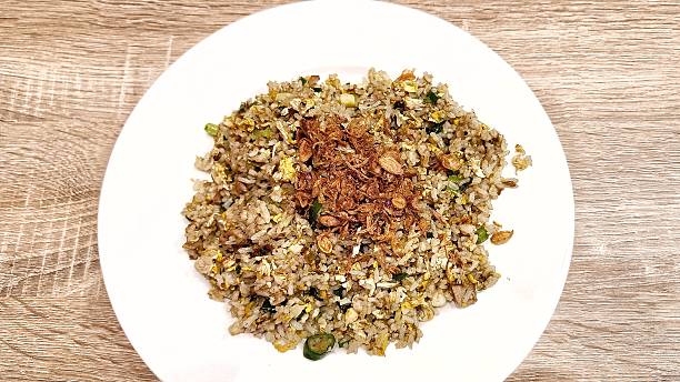 High Angle View of Delicious fried rice topped with fried onions served on a white plate