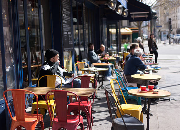 Paris, France - March 30, 2025: A colorful sidewalk cafe with customers at the corner of Rue du Faubourg Saint Antoine and Rue Faidherbe in the 11th arrondissement.