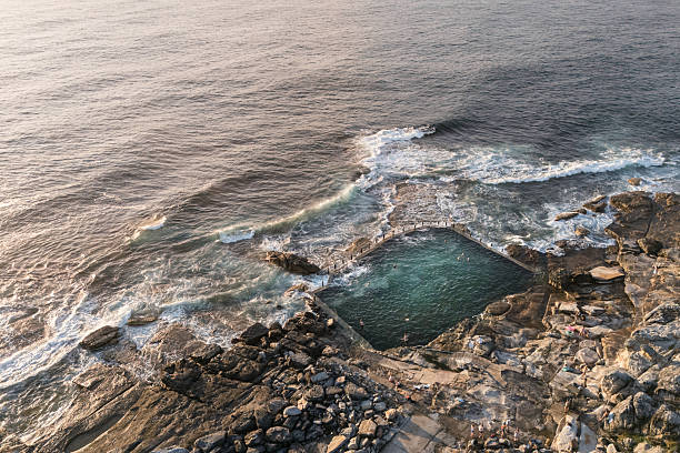 Stunning early morning aerial view of the Maroubra Rockpool in Sydney, Australia. Captured by drone at sunrise, showcasing natural beauty and coastal serenity.