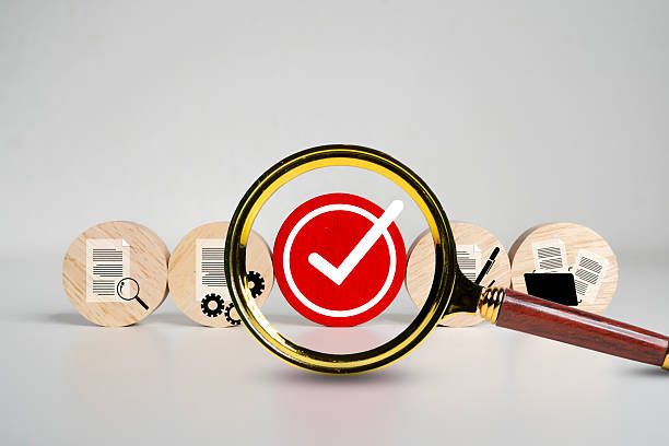 istock Magnifying Glass Focuses on Red Check Mark with Document Icons, Quality Control and Verification Concept 2217222649