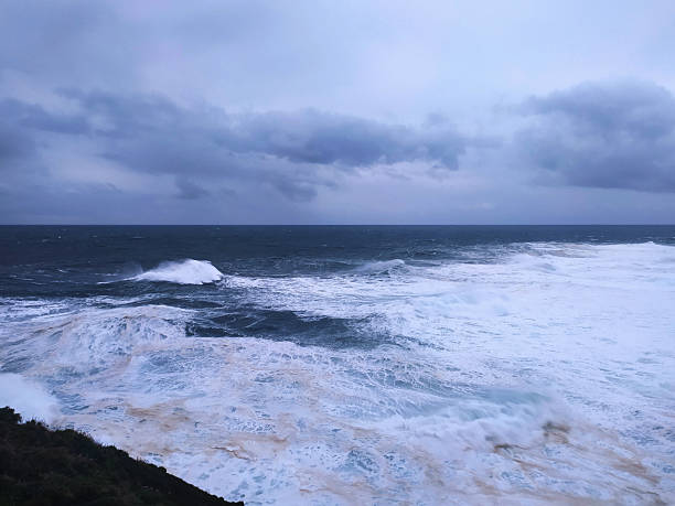 istock Dramatic ocean view with large waves crashing under a stormy sky. Evokes power, resilience, and the force of nature. Ideal for themes of challenge, adventure, or environmental awareness. 2217224537