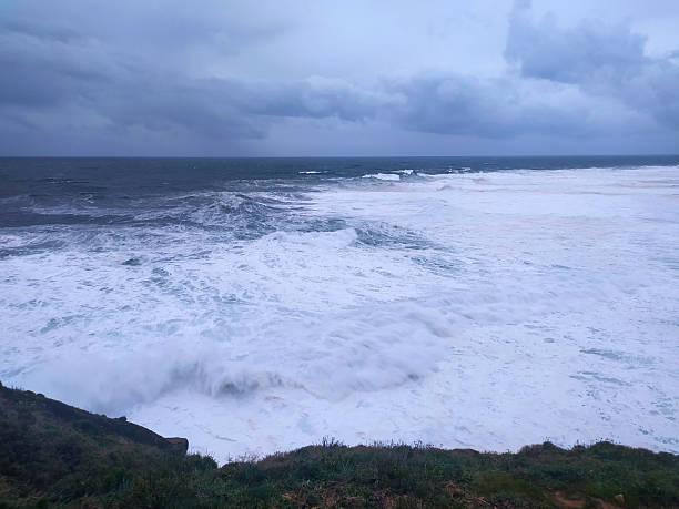 istock Dramatic ocean scene with powerful waves crashing against the shore under a stormy sky. Evokes themes of natures power, resilience, and the beauty of wild landscapes. 2217224666