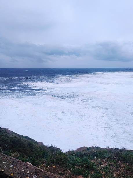 istock Dramatic seascape featuring powerful waves crashing against the shore under a moody sky. Evokes themes of resilience, natures force, and coastal beauty. 2217224676