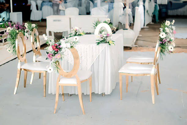 White formal chairs decorated with light brown wedding material