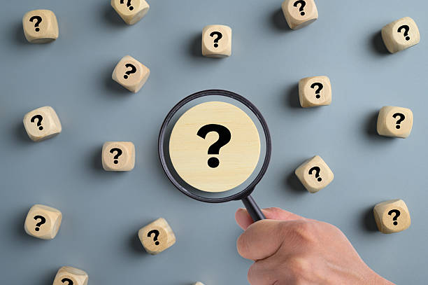 Question mark related to analysis or problem solving Hand holding magnifying glass over question mark scattered across background, Troubleshooting, Analysis and inspection concept FAQ stock pictures, royalty-free photos & images