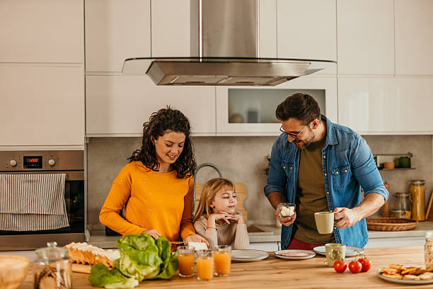 istock Happy family preparing breakfast together in modern kitchen 2217233682