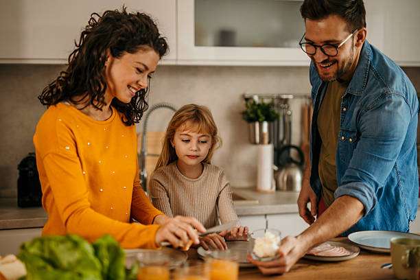istock Happy family preparing breakfast together in modern kitchen 2217233686
