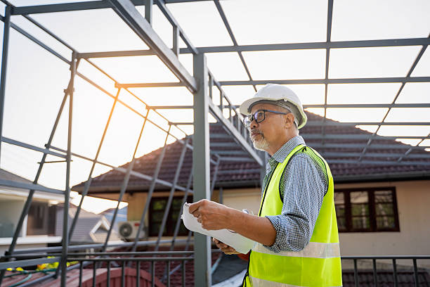 istock Senior male engineer uses tablet and blueprints to plan warehouse construction work. 2217239094
