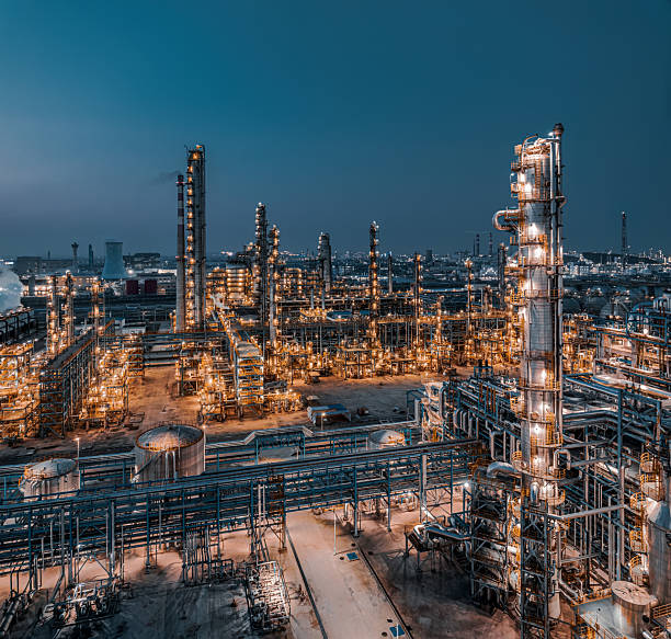 istock Brightly oil refinery and chemical processing plant functioning through the night in Asia. Energy production background. 2217243417