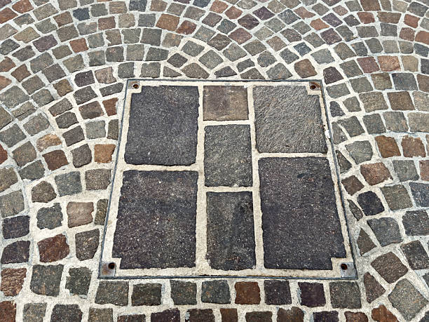 Cobblestone pattern with manhole cover on pavement