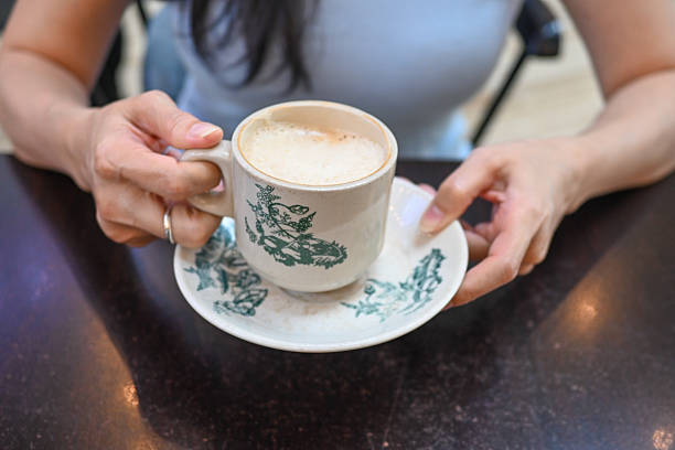 istock A young woman holds a coffee spoon and stirs hot coffee. 2217246512