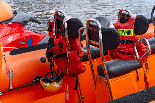 Orange rescue boat equipped with life jackets and a protective helmet, featuring the label \