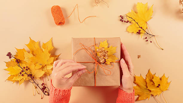 istock Process of wrapping and decorating presents with dried leaves 2217257177