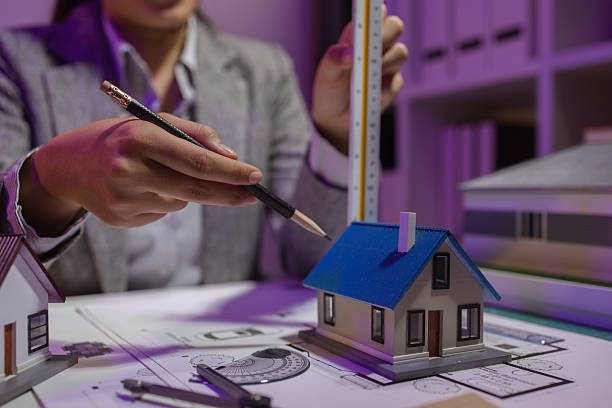 istock an experienced female engineer is giving a final check to a house model in her private office to make sure it meets the blueprints and meets the construction deadline 2217262866