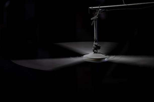 istock A industrial ceiling fan with three blades spins rapidly against a dark background, illuminated by a single light. 2217268381