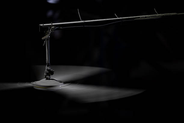 istock A industrial ceiling fan with three blades spins rapidly against a dark background, illuminated by a single light. 2217268383