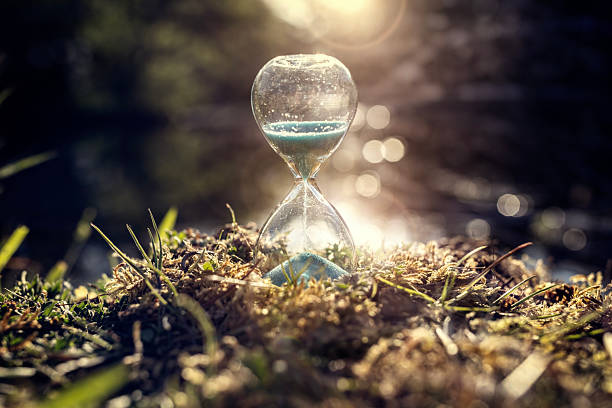 istock Hourglass in grass by river at sunset background 2217268770