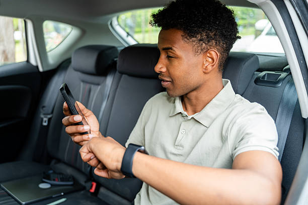istock businessman using mobile phone and smartwatch in car 2217270165