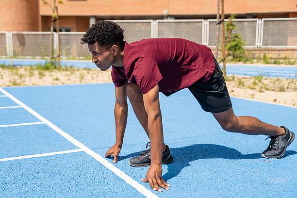 istock Focused athlete crouching at starting line on running track 2217271913