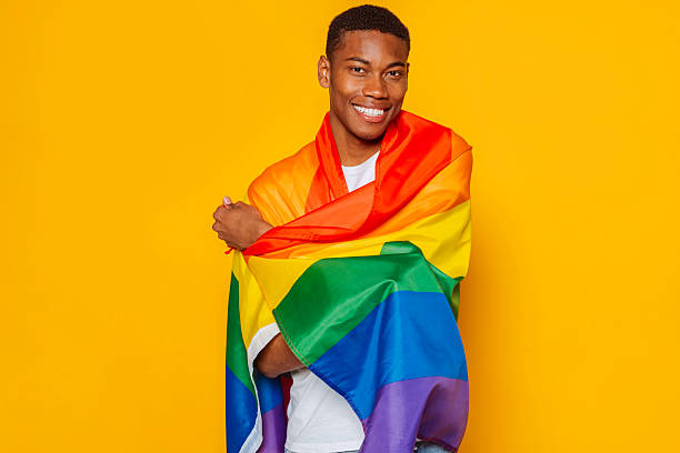 istock Happy young man wrapped in a rainbow flag celebrating pride month 2217272306