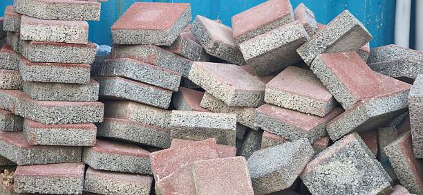Stacked concrete sidewalk blocks in red and gray tones. Ideal for paving sidewalks, walkways, plazas, and urban landscapes.