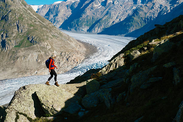 Senior woman hiking the Aletsch Glacier trail between Bettmeralp to Marjelen in the Valais district of Switzerland. This is the section nearer Marjelen.