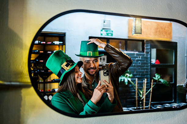 Friends photographing each other on mirror on saint patrick's day on a bar