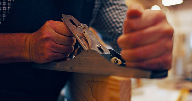 istock Hands, industry and plane with man in workshop for manufacturing or production process. Creative, design and equipment with carpenter closeup in woodworking studio for craftsmanship or manual labor 2217280206