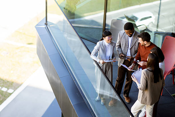 istock Group of professionals collaborating on project details in modern office space during sunny day 2217281143