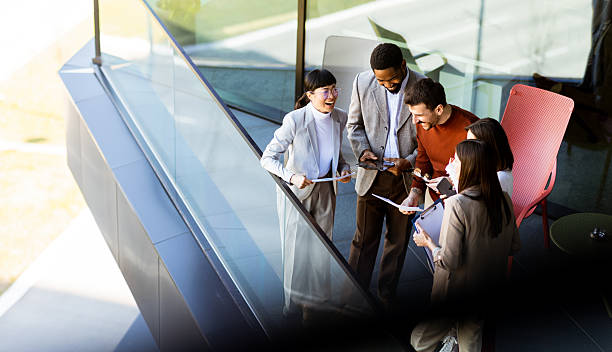 istock Group of professionals collaborating on project details in modern office space during sunny day 2217281144