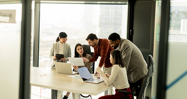 istock Team collaborates in modern office setting on innovative project with laptops and discussion 2217281145