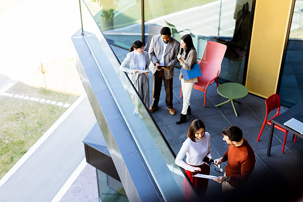 istock Colleagues engage in a productive discussion on a modern office balcony during a sunny afternoon 2217281147