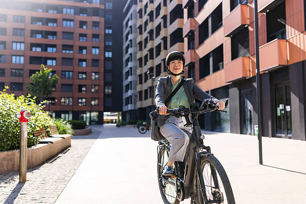 istock Woman riding a bicycle through a modern cityscape under the sun 2217284484