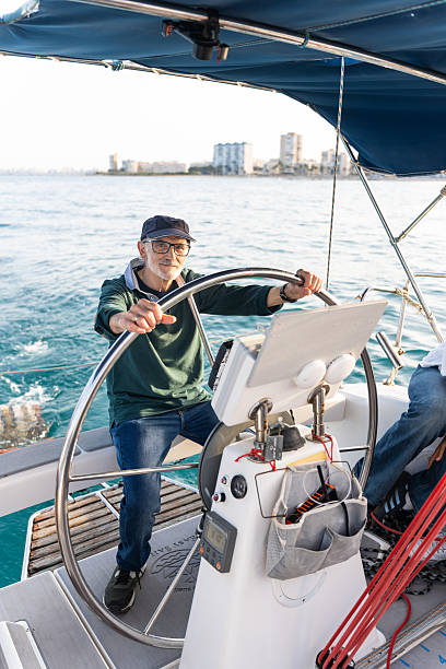 istock Senior man steering sailboat on sunny day 2217285315