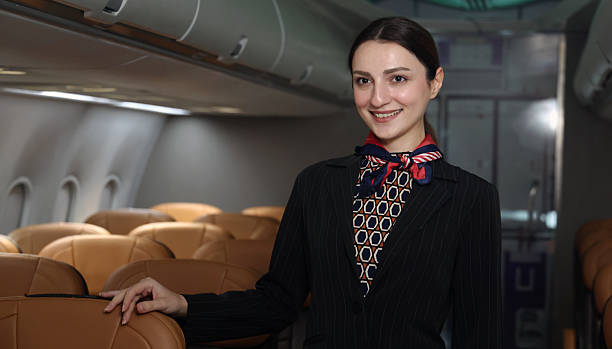 istock Flight attendant or Air Hostess. A friendly flight attendant stand confidently inside an airplane cabin. Professional hospitality and elegant uniform. Aviation service travel airline Flight attendant. 2217287521