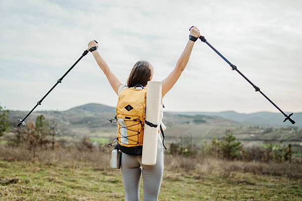 istock Young woman hike or trek and explore scenic forest with hiking sticks 2217288721