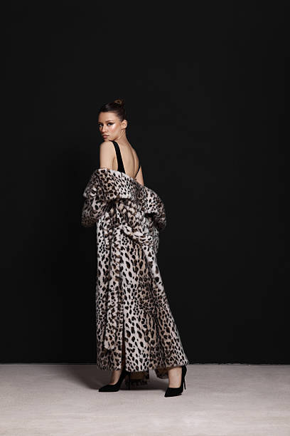 istock model poses confidently in an eye-catching leopard print gown with a dramatic silhouette in a studio. black backdrop enhances the gowns striking design and luxurious feel 2217289693