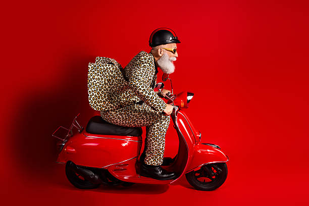 istock Elderly gentleman in leopard print suit on red motor scooter with red backdrop, combining fun, vibrancy, and elegant style 2217289927