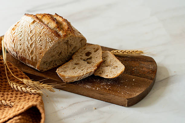 istock Freshly baked sourdough bread with a jar of starter and rustic cloth 2217292076