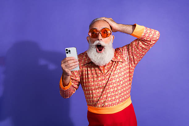 istock Vintage styled elderly man reacts with excitement while holding smartphone 2217292125
