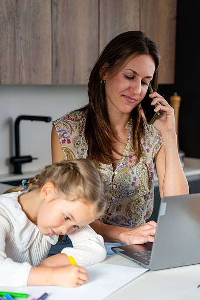 istock Mother working from home and talking on the phone while her daughter is drawing 2217293498