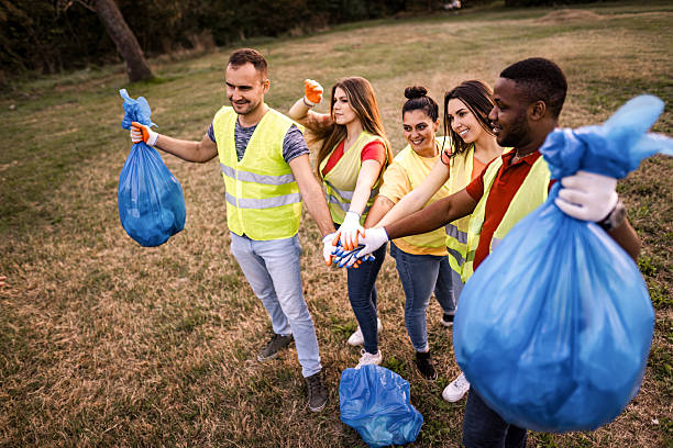istock Volunteers joining hands after picking up trash in a park 2217297173