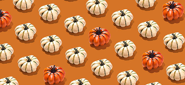 istock Banner with orange and white pumpkins pattern on orange background. Wallpaper Halloween concept background 2217304575