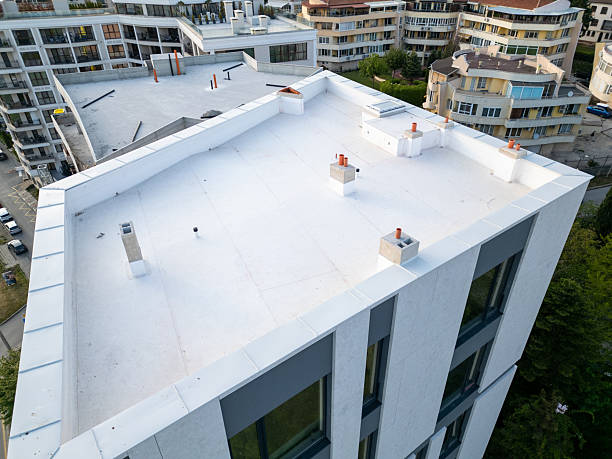 istock Aerial view of modern residential buildings under construction, featuring flat white rooftops, scaffolding, and unfinished facades. Surrounding neighborhood with completed homes in background 2217304871